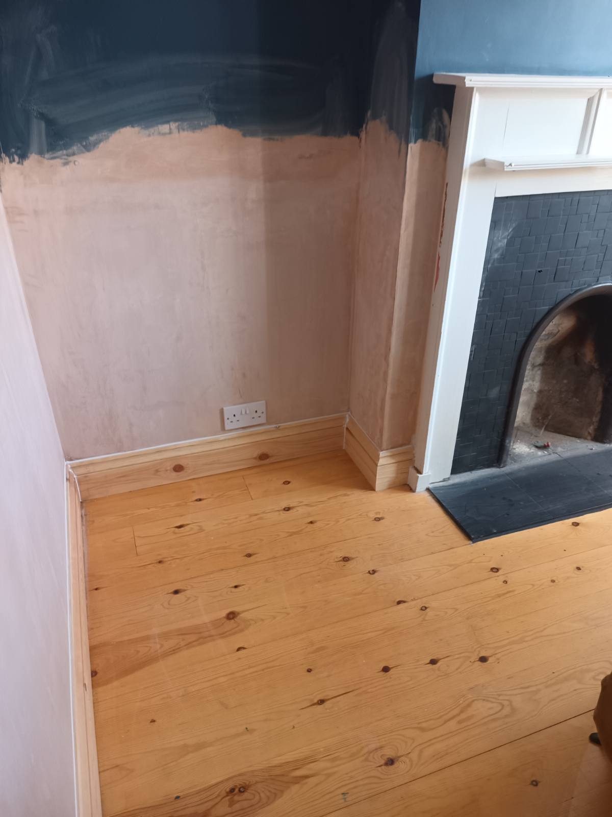 Freshly plastered room with reinstated fireplace surround